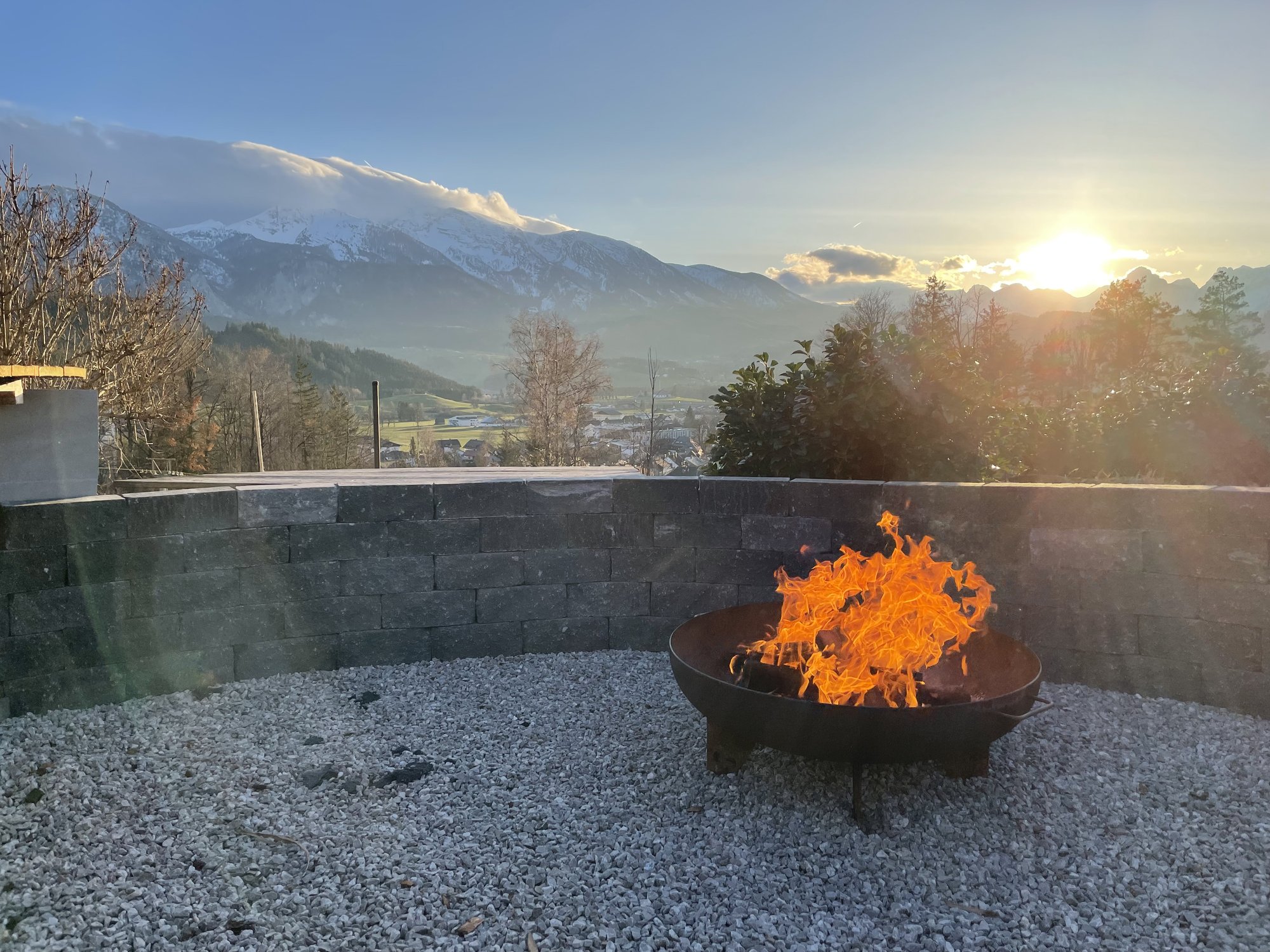 Lagerfeuer mit Bergblick bei Dämmerung